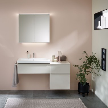 Pastel renklerde bir duvarın önünde Geberit banyo mobilyaları, lavabo ve aynalı dolap